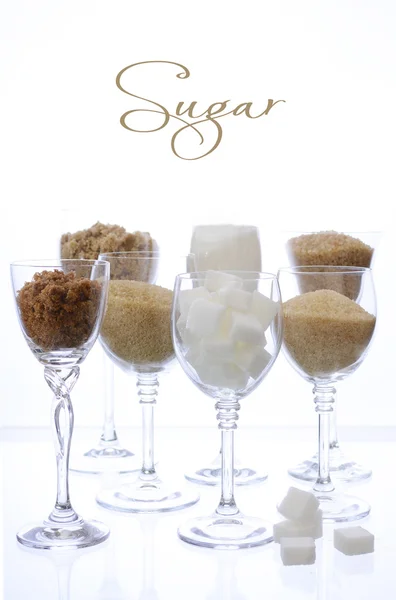 Different types of sugar in glasses on white. — Stock Photo, Image