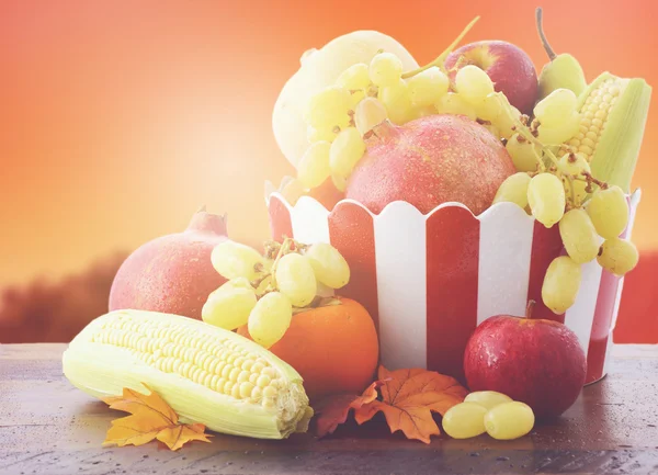Mísa na podzim ovoce a zeleniny s západ slunce na pozadí. — Stock fotografie