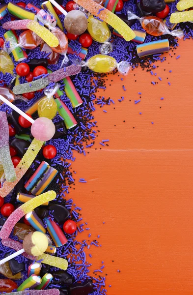 Яскраві барвисті цукерки на помаранчевому дерев'яному фоні . — стокове фото
