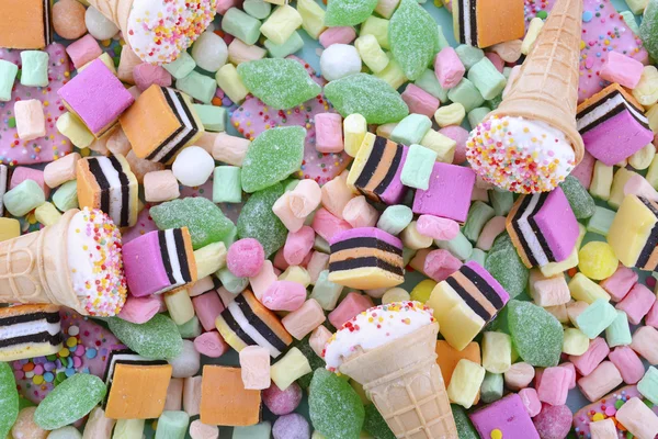 Bright colorful candy on pale blue wood table. — Stockfoto