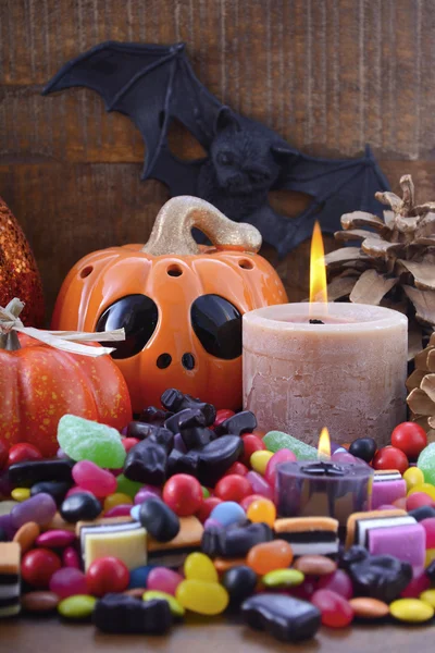 Хеллоуїн цукерки з гарбузами на фоні темного дерева . — стокове фото