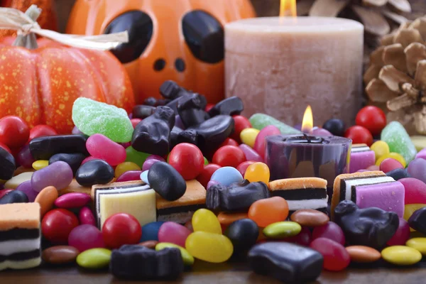 Halloween Candy com abóboras no fundo de madeira escura . — Fotografia de Stock