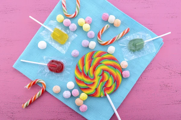 Surtido de dulces y piruletas en mesa de madera rosa . — Foto de Stock