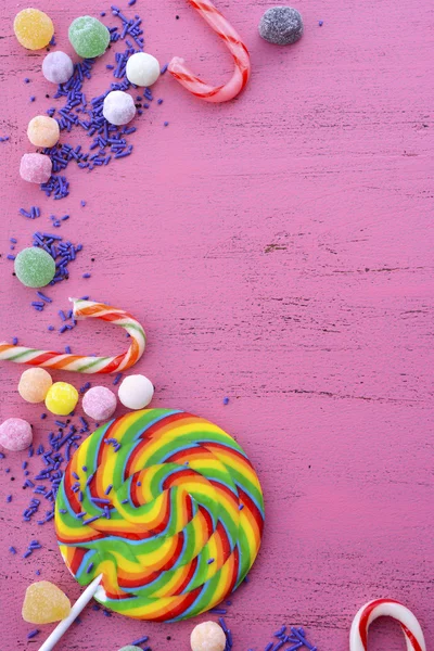 Assorted candy and lollipop on pink wood table. — Stock Photo, Image