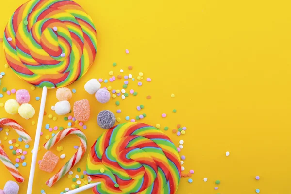 Rainbow lollipop candy on bright yellow wood table. — Stock Image Rainbow lollipop candy on bright yellow wood table. Royalty Free Stock Images