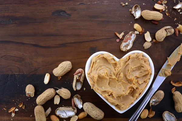 Burro di arachidi in piatto a forma di cuore con spazio copia — Foto Stock