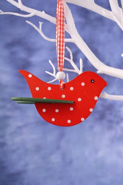 Red bird ornament hanging from white branch. — Stock Photo, Image