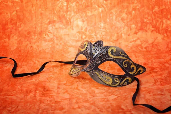 Mardi Gras maska na pomarańczowym tle. — Zdjęcie stockowe