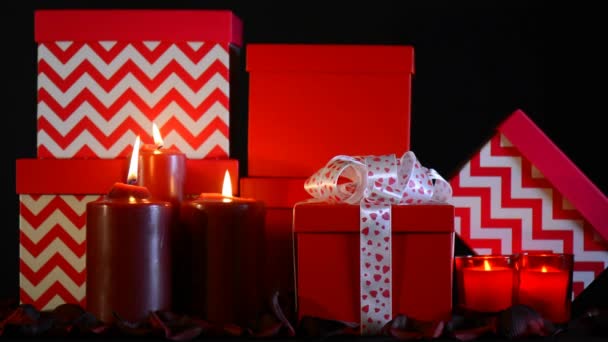 Romantique Valentine grande pile de cadeaux rouges dans la lumière de la bougie sur un fond noir, statique . — Video