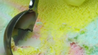 Yavaşça kutudan gökkuşağı dondurmasını çıkar. Dairesel dondurma kepçesiyle.