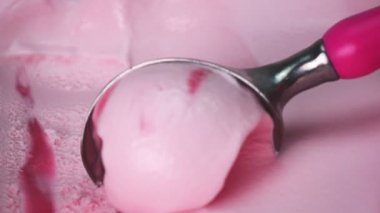 Yakın plan çilekli dondurma kaşıkla kepçelendi. Dondurmanın desenleri ve renkleri.