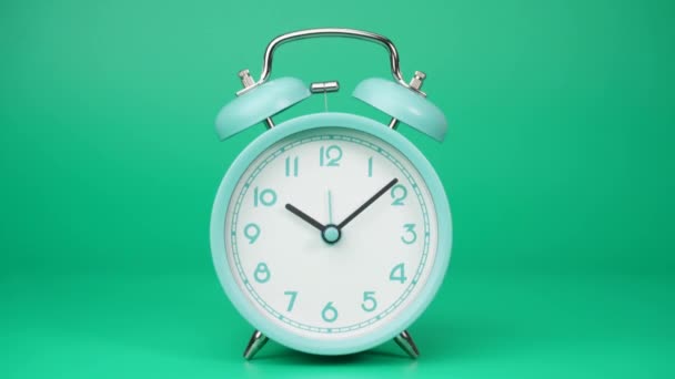 時間の経過 青い目覚まし時計は時間の経過を示しています 時計の針の動きはすぐに過ぎ去った 緑の背景に — ストック動画