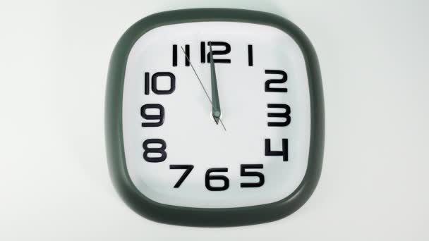 白い壁の時計は時を告げる 時計の短くて長い手の回転 白地に — ストック動画