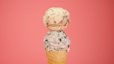 Çikolata parçalı dondurma üstüne dondurma. Dondurma ve dondurma külahı pembe arka planda waffle konisi. Ön manzara yiyecek konsepti..                         