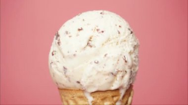 Time lapse, Vanilla ice cream on a cone. Melting of ice cream texture. On the pink background.
