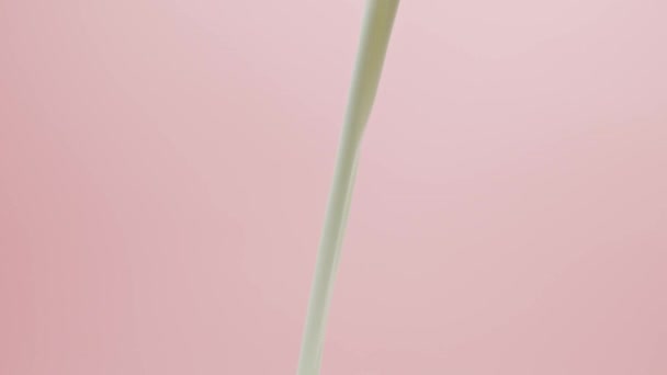 白い液体ピンクの背景ミルク — ストック動画