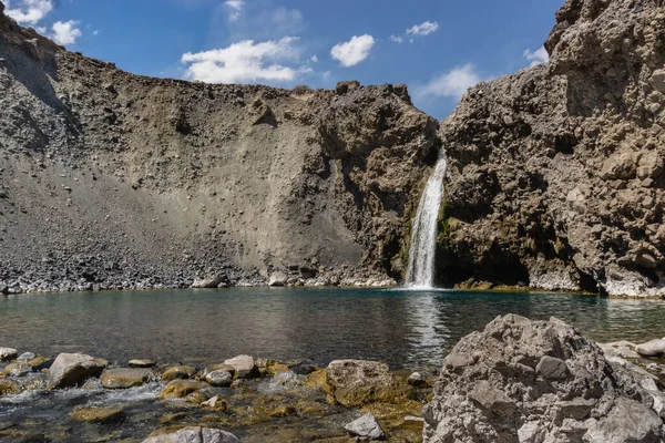 Impressive horizontal photo of turquoise light blue waterfall located in the Cajon del Maipo, Andes Mountains called Salto el Yeso, Chilean Patagonia