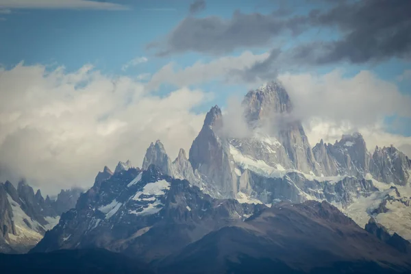 高耸的道路 在地平线上有一座岩石和雪山的山峰 阿根廷菲茨罗伊山横向摄影 — 图库照片