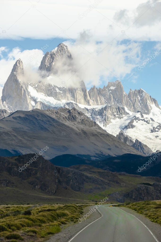 Asphalted road with the peaks of a rocky and snowy mountain on the horizon. Fitz Roy mountain in Argentina vertical Photograph