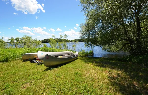 Canoes parked on green grass — Stock Photo, Image