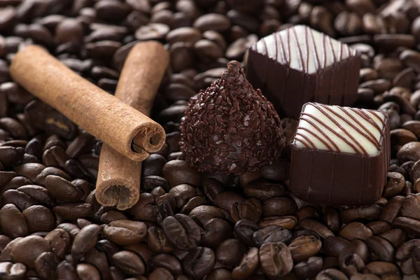 Chocolate with cinnamon sticks on coffee background, selective f Rechtenvrije Stockfoto's