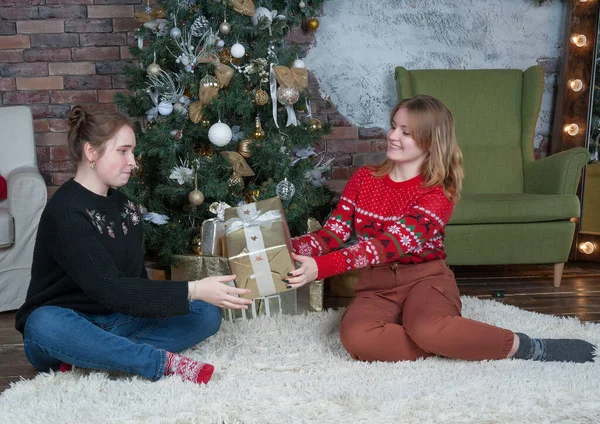 Zwei Fröhliche Mädchen Sitzen Unter Einem Geschmückten Weihnachtsbaum — Stockfoto
