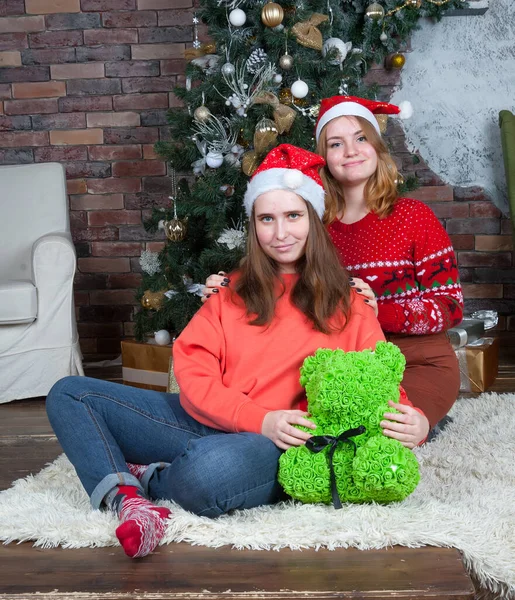 Meninas felizes sentadas sob a árvore de natal no ano novo — Fotografia de Stock