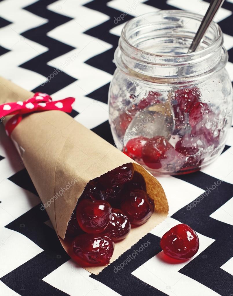 Glace cherries in paper cone on chevron background