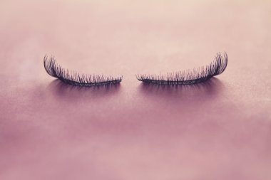 Close up false eyelashes on pink background clipart