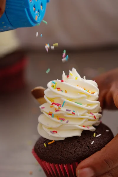 Movimento de polvilhas que caem sobre a um cupcake — Fotografia de Stock