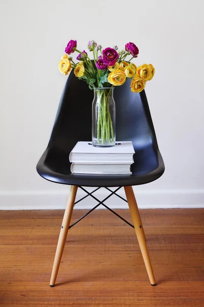 Sarı ve mor çiçekler ile çağdaş siyah yemek sandalyesi — Stok fotoğraf