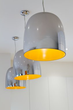 Three chrome and yellow contemporary kitchen pendant lighting clipart