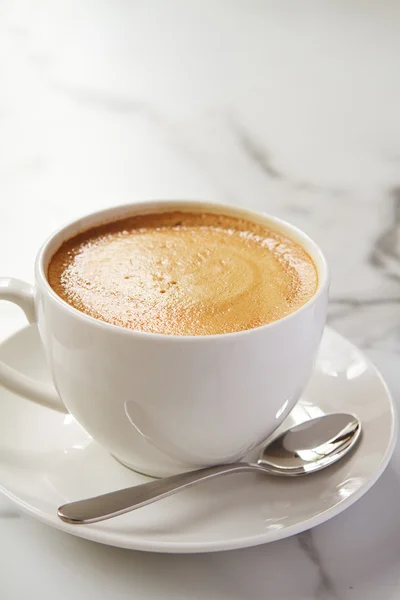 Café con leche de capuchino o latte en taza blanca y platillo en un café — Foto de Stock