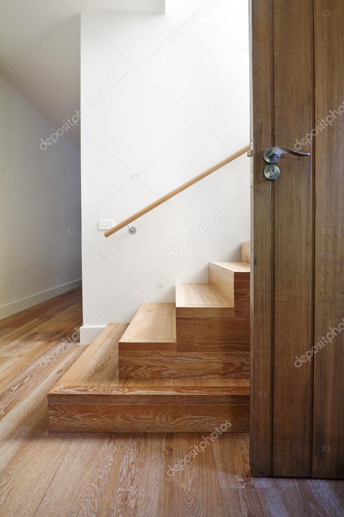 Modern staircase of oak wood beside front door