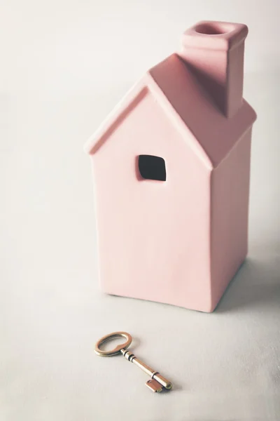 Toy pink house with gold key — Stockfoto