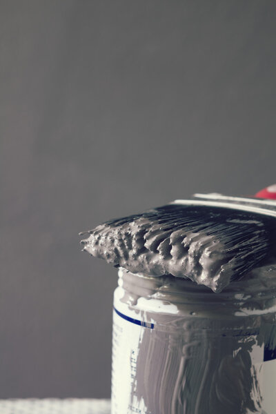 Close up of wet paint on brush on sample pot vertical