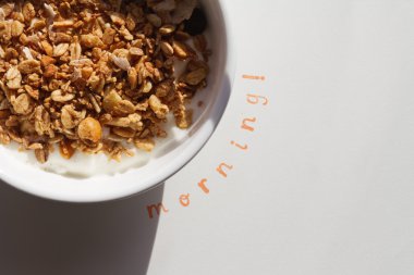 The word Morning stamped next to a bowl of muesli and yogurt clipart