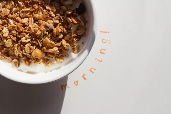Slovo ráno razítkem vedle misku müsli a jogurt — Stock fotografie