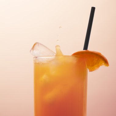 Close up of ice dropped into vodka orange cocktail clipart