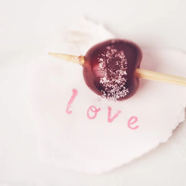 Açúcar de cereja vermelho revestido em um pau com amor de palavra — Fotografia de Stock