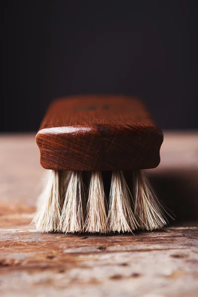 Primo piano di una spazzola lucentezza scarpa su uno sfondo rustico — Foto Stock