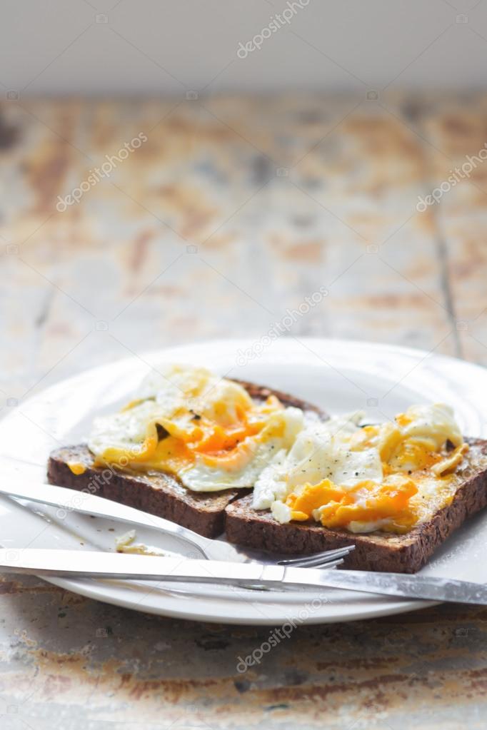 Close up of mashed poached eggs on a rustic kitchen table