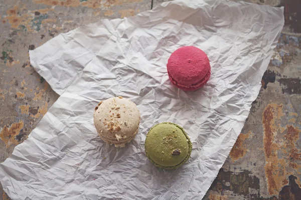 Overhead view of three yummy macaroons on crumpled paper — Stock Photo, Image