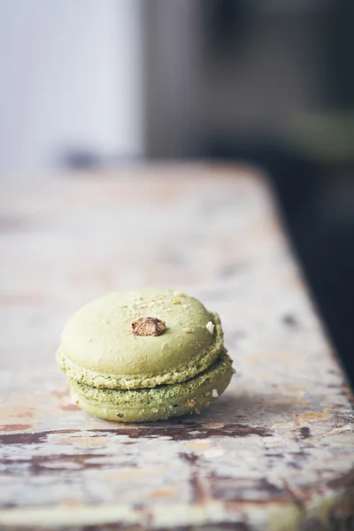 Close up of pistachio macaroon on rustic table — Stock Photo, Image