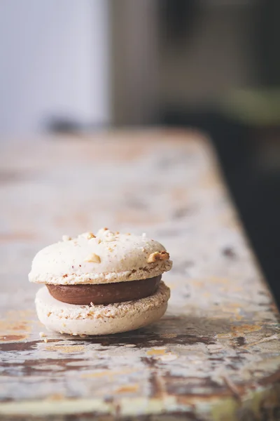 Close up of caramel coffee macaroon on rustic tabletop — Stock Photo, Image