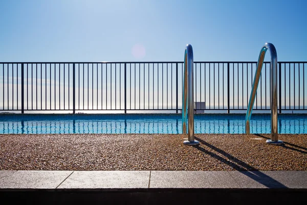 Borde de la piscina con escalera y fondo de cielo — Foto de Stock