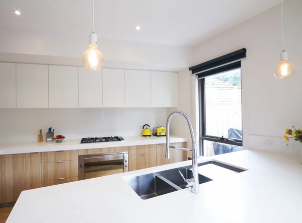 Modern kitchen with pendant lighting and sunken sink — Stock Photo, Image