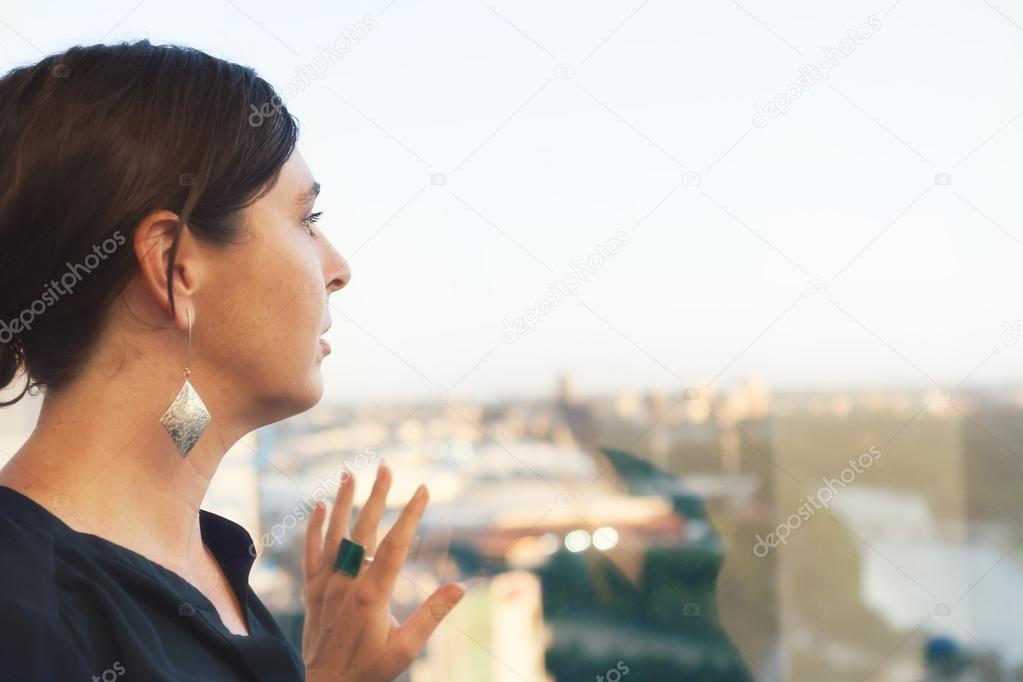 Professional female looking out office building window