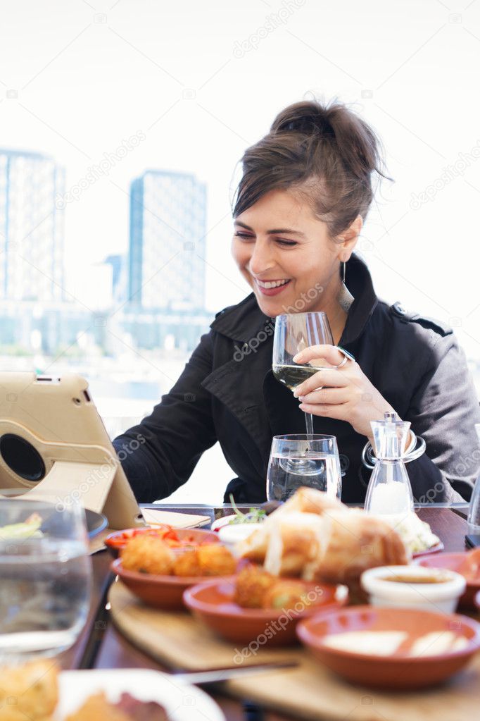 Woman working on computer tablet at outdoor restaurant