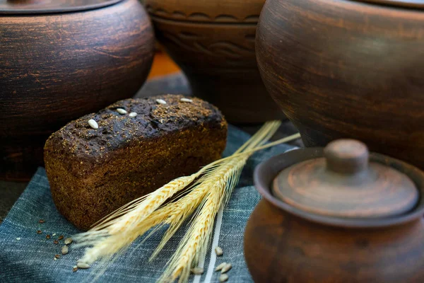 Çavdar ekmeği, ayçiçeği tohumları ve kil çömlekleri.